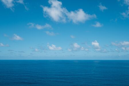 blue sky with clouds over water - ocean horizon , sea backgroundの写真素材