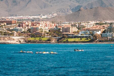 group of jet ski in ocean with hotels at coast in backgroundの写真素材