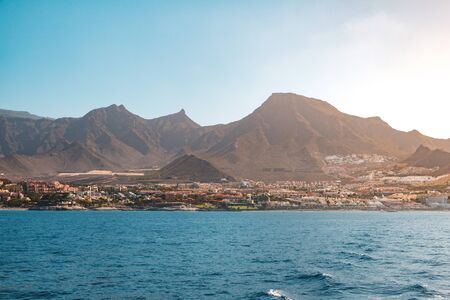 ocean view on shore with hotels and city and scenic mountain background - Coast of Tenerife -の写真素材