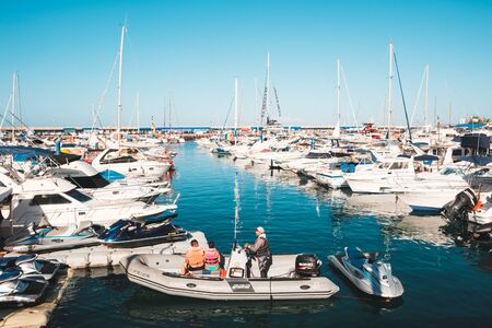 People on motorboat with jet skis at yacht and sailboat harbor in Costa Adeje, Tenerifeのeditorial素材