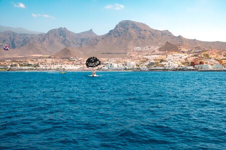 Ocean view on coast of Tenerife (Coasta Adeje) with motor boat and parasailのeditorial素材