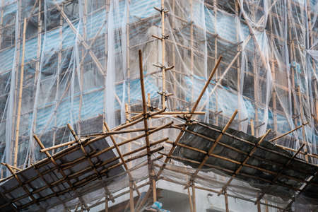 Bamboo scaffolding on building facade, construction site -