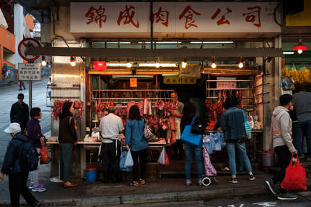 HongKong, China - November, 2019: Butcher selling  meat to people on street market store in Hong...