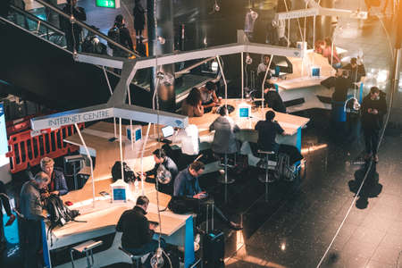 Amsterdam, Netherlands - November, 2019: People using mobile phone at internet center on airport (Schipol airport) in Amsterdamのeditorial素材