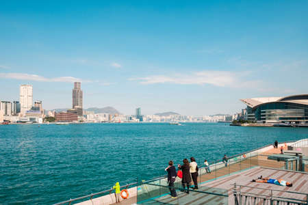 HongKong, China - November, 2019: People at Public waterside promenade with city skyline of Hong Kong behind Victoria Harborのeditorial素材