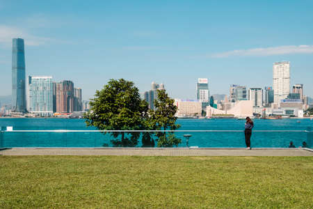 HongKong, China - November, 2019: Public park, cityscape and Kowloon skyline view from Central over Victoria Harbor, HongKongのeditorial素材