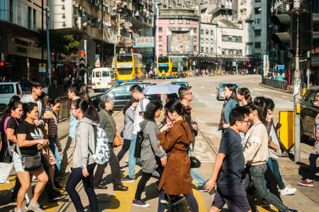 HongKong, China - November, 2019: Cityscape, traffic and people crossing street in Hong Kong city