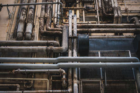 dirty pipes on building exterior, industrial background -の写真素材