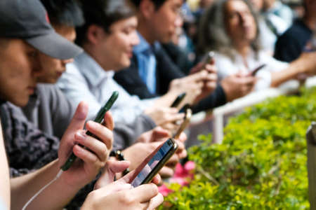 Hong Kong, November, 2019: People looking on mobile phone at Horse racing course in Hong Kong Jockey Clubのeditorial素材