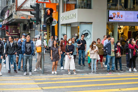 Hong Kong - November, 2019: Crowd of people waiting on traffic light to cross the street in Hong...