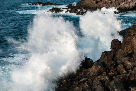 Waves crashing at rocks. Stormy weather at ocean coastの写真素材