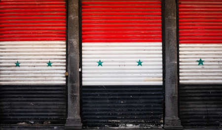 Damascus, Syria - May, 2022: Syrian flag on closed shop shutters in empty market (Suq Al Hamidiyah) during Eid holidays in Damascusのeditorial素材