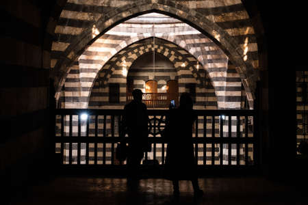 Damascus, Syria -May, 2022: Tourist couple taking picture inside historic Old City of Damascus (Khan As'ad Pasha)の写真素材