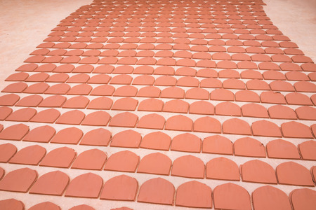 Asian ceramic roof tiles are drying in production workshopの写真素材