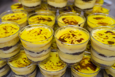 Cups of 9-layer chocolate mango and coconut cream cake. Ingredients: mango, coconut extract, yellow, yellow lime, whipped cream, butter, flour, egg, cocoa, rum wine, sugar, gelatine..の写真素材