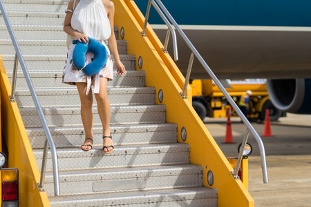 Closeup airplane stairs with passenger going down stairs from airplane just landedの写真素材