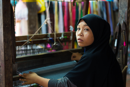An Giang, Vietnam - Nov 29, 2014: Champa woman weaves textile at home at Cham village, Mekong delta, Vietnamのeditorial素材