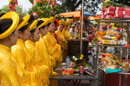 Quang Ninh, Vietnam - Mar 22, 2015: Old women in traditional dress Ao Dai performing old buddhism ceremonial in festive days at Cua Ong temple, Van Donのeditorial素材