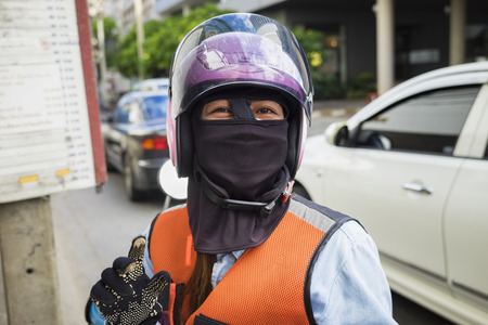 Motorcycle taxi man wearing helmet and cloth mask in Bangkok, Thailandのeditorial素材