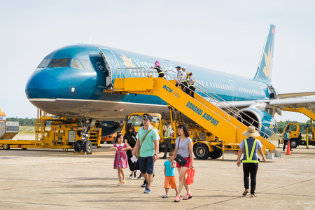 Quang Binh, Vietnam - June 16, 2016: Passengers going down with stairs from airplane just landed at Dong Hoi airportのeditorial素材