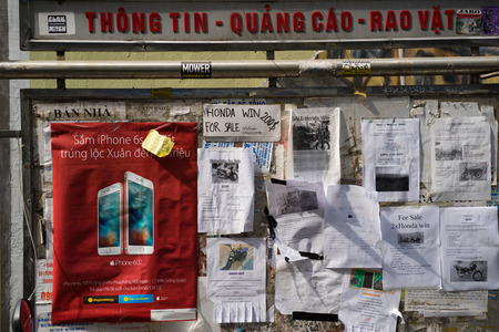 Hanoi, Vietnam - Feb 28, 2016: Messy advertisement papers on board in Hanoi streetのeditorial素材