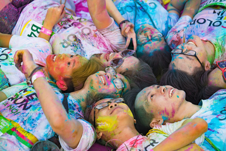 Hanoi, Vietnam - Sep 23, 2015: Group of teenagers taking photo at public color run event in Hanoi capital city. Hundreds of people joined the joyful race named "Color Me Run"のeditorial素材