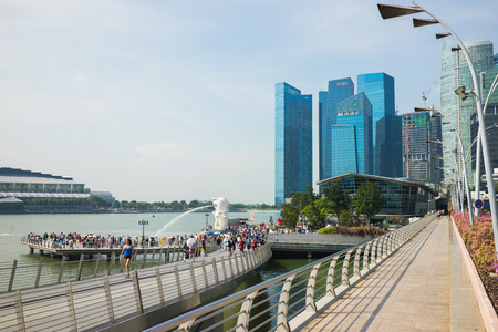 Singapore - Apr 30, 2016: Marina Bay with walking bridge, crowded people and high buildings on backgroundのeditorial素材