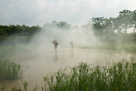 Bac Ninh, Vietnam - May 29, 2016: Children catching fish by fishing bamboo trap - the old traditional way, on pond in Bac Ninh provinceのeditorial素材