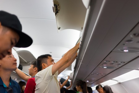 Nha Trang, Vietnam - July 31, 2016: Aircraft passengers taking baggage from cabin after the airplane landed at Cam Ranh international airportのeditorial素材