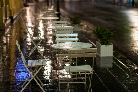 Wet coffee table and chairs after heavy rain at night