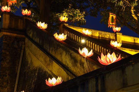 Beautiful flower garlands and colored lanterns on ancient architectural buildingの写真素材