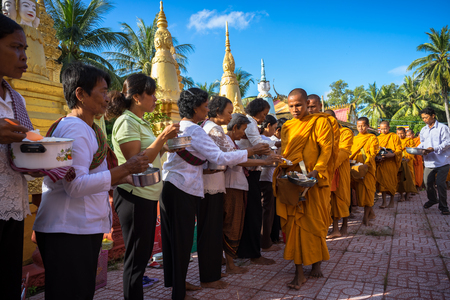 An Giang, Vietnam - Dec 6, 2016: Buddhist monk in south of Vietnam stand in a row waiting people put rice and food offerings in their alms bowl in Chau Doc districtのeditorial素材
