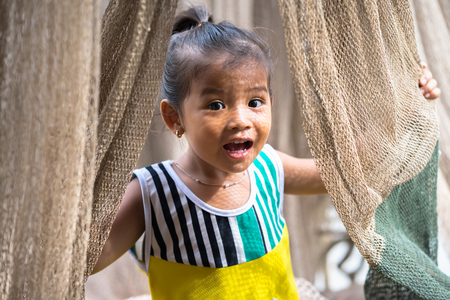 Ca Mau, Vietnam - Dec 6, 2016: Portrait of little girl playing with casting net in Ngoc Hien, Ca Mau district, Vietnamのeditorial素材