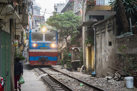 Hanoi, Vietnam - Dec 19, 2016: Vietnam train running on railway on narrow street between resident houses in Le Duan streetのeditorial素材
