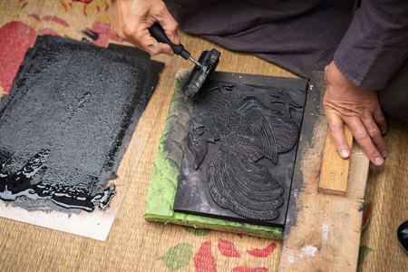 Hanoi, Vietnam - Jun 22, 2017: Old Dong Ho village artist making Dong Ho folk woodcut painting in communal house, Quoc Oai district. Concept of cultural preservationのeditorial素材