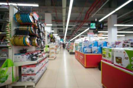 Supermarket blurred background with colorful shelves and unrecognizable customersの写真素材