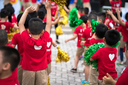 School children raising hands up on celebration dayの写真素材