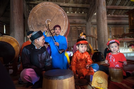 Hanoi, Vietnam - Jun 22, 2017: Vietnamese old traditional folk singer with children learning to play...