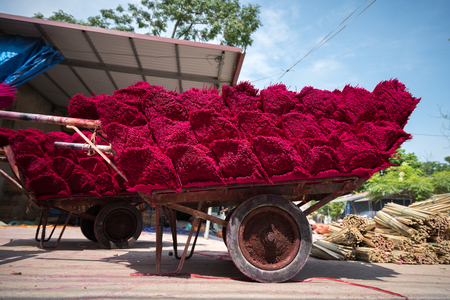 Incense sticks drying outdoor with Vietnamese woman wearing conical hat in north of Vietnamの写真素材