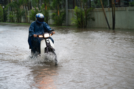 A motorcyclist rides along a flooded street in Hanoi city, Vietnamの写真素材