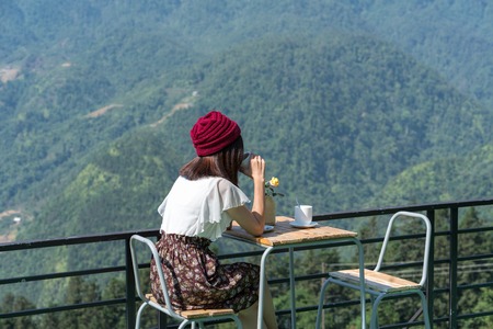 A girl drinking coffee in the morning in the mountainsの写真素材