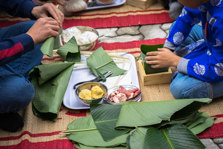 The son learning to make Chung cake by hands with his father closeup, Chung cake is the most important traditional Vietnamese lunar New Year (Tet) food.の写真素材