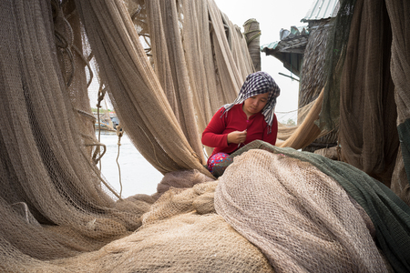 Ca Mau, Vietnam - Dec 6, 2016: Vietnamese woman mending casting net in Ngoc Hien, Ca Mau district, Vietnamのeditorial素材