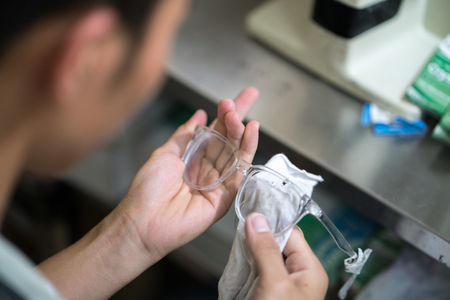 Eye glasses is cleaning by worker after milling in workshopの写真素材