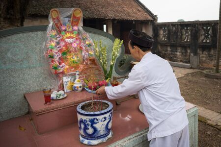 Hanoi, Vietnam - Jun 22, 2017: Old man preparing worship offerings on altar on holiday in communal house at So village, Quoc Oai district.のeditorial素材