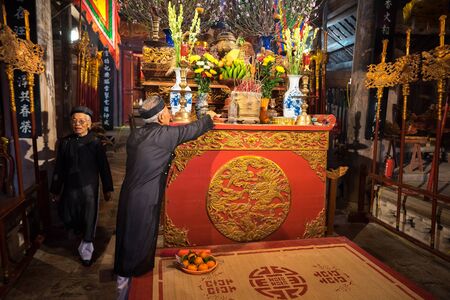 Hanoi, Vietnam - Jun 22, 2017: Old man preparing worship offerings on altar on holiday in communal house at So village, Quoc Oai district.のeditorial素材