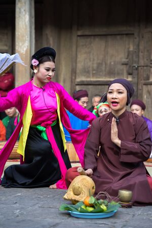 Hanoi, Vietnam - Jun 22, 2017: An act of folk music and dance called Thi Mau visits temple, the most popular act of Cheo in Vietnam, on courtyard of communal house at So village, Quoc Oai district,のeditorial素材