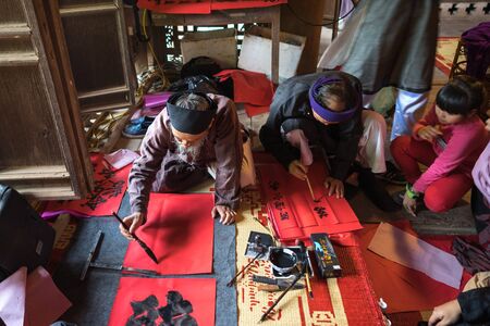 Hanoi, Vietnam - Jun 22, 2017: Scholar writes Chinese calligraphy characters in communal house at So village, Quoc Oai district. Calligraphy giving is a popular tradition during Tet holidayのeditorial素材