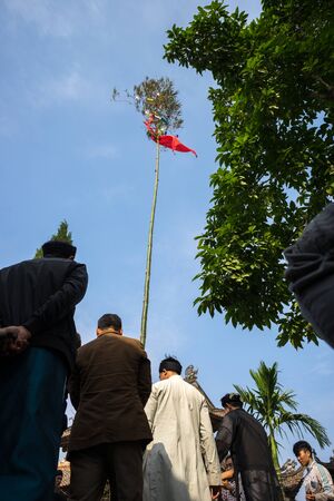 Hanoi, Vietnam - Jun 22, 2017: Raising Neu tree rituals in communal house at So village, Quoc Oai district. The bamboo pole placed in front of house on the last day of the lunar year to expel evilsのeditorial素材