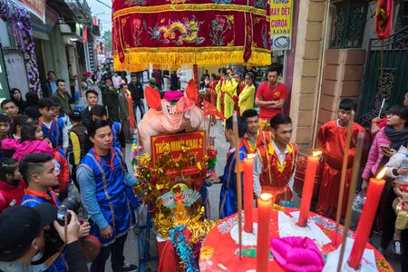 Hanoi, Vietnam - Feb 9, 2017: Pig procession festival in La Phu village. People wearing formal uniform and going from the main path of the village to the temple.のeditorial素材
